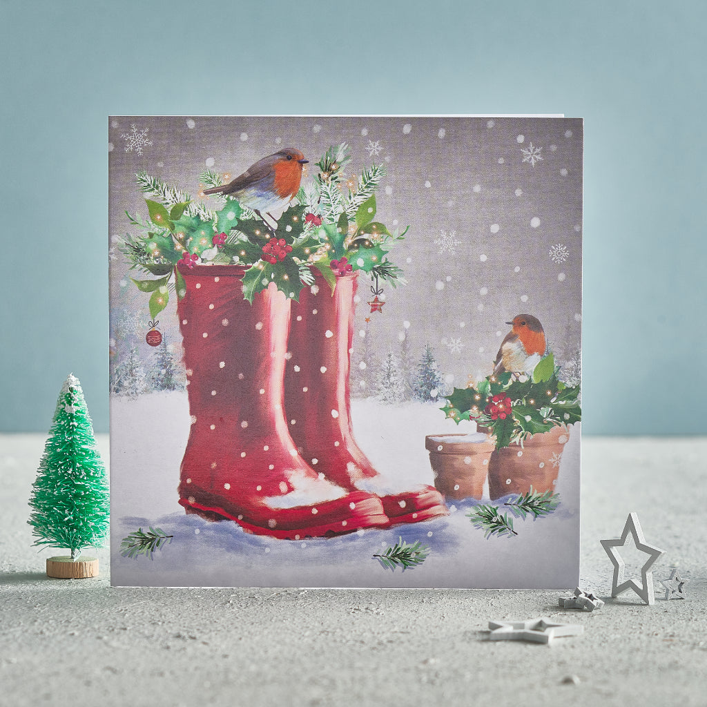 A Christmas card featuring two robins and a pair of wellies in the snow