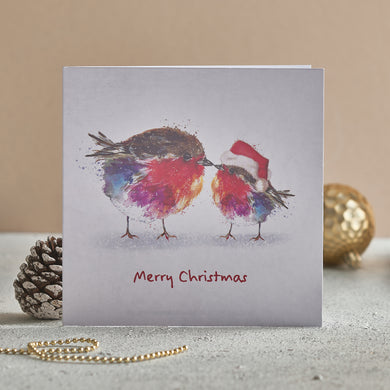 A Christmas card with two robins on the front. One adult and one young illustrated robin in a Santa hat