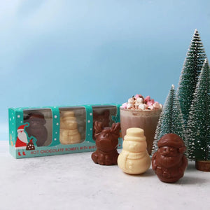 Set of three Christmas Character hot chocolate bombes, with a festive backdrop. 