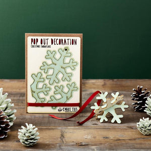 Snowflake pop out card among pine cones